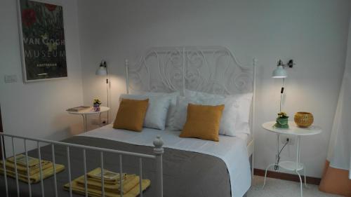 een slaapkamer met een wit bed met gele kussens bij acasadienrico in Lecce