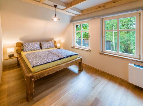 a bedroom with a wooden bed in a room with windows at Adelinenhof - Ferienapartments, Fasten, Wellness & Gesundheit in Burg