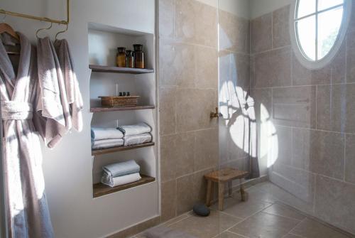 a bathroom with a shower with towels and a window at Domaine Les Martins - Gordes in Gordes