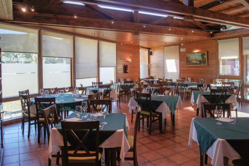 a restaurant with tables and chairs with green tablecloths at Las Cabañas in Vegaquemada