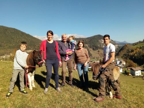 a group of people standing in a field with a horse at Hinteregghof in Forstau