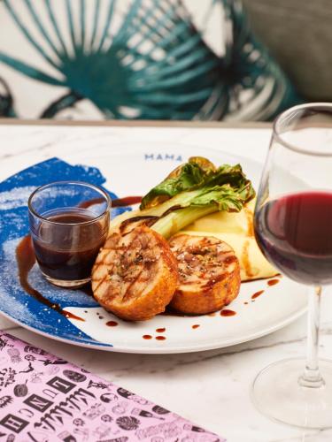 a plate of food with bread and a glass of wine at Mama Shelter Toulouse in Toulouse