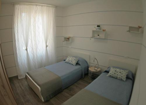 a bedroom with two twin beds and a window at Da Sabbi in La Spezia
