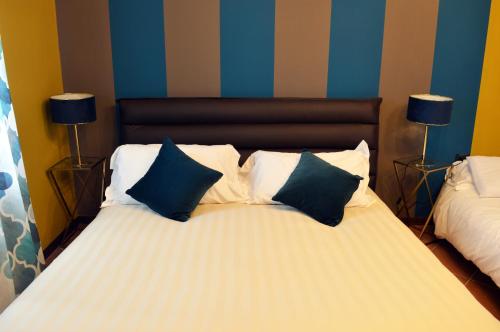 a bed with blue and white pillows on it at Panoramic Villa Garassino - country rooms and fine restaurant in Treiso