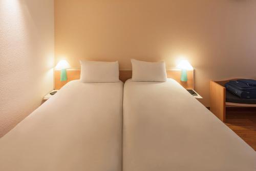 a bedroom with two large beds with lights on them at ibis Nürnberg Hauptbahnhof in Nürnberg