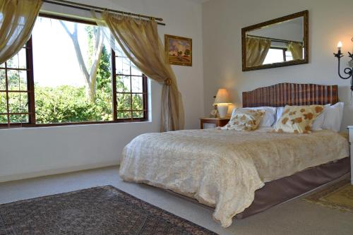 1 dormitorio con 1 cama grande y 2 ventanas en Sea Valley Villa, en Port Alfred