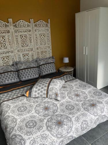 ein Schlafzimmer mit einem großen Bett mit gemusterter Decke in der Unterkunft Chez Frédérique et Jean-Claude in Les Taillades
