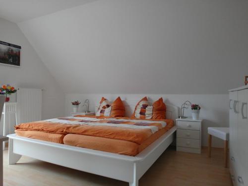 a bedroom with a large bed with orange pillows at FEWO1 1OG Scheldt in Nümbrecht