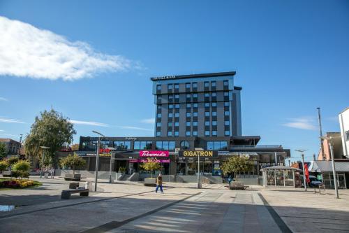 a large building with a person walking in front of it at Hotel Ana Lux Spa in Pirot