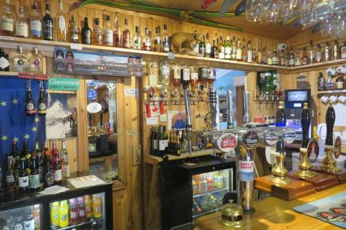 un bar lleno de muchas botellas de alcohol en Pine Marten Bar Glenmore Pods, en Aviemore