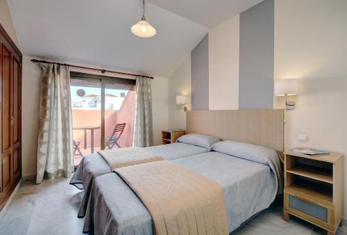 a hotel room with a bed and a balcony at Sanpedro Apartamentos Marbella in Marbella