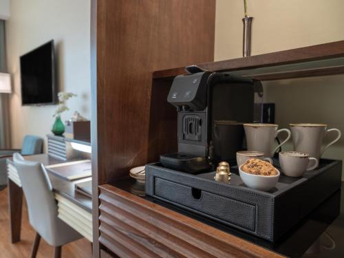 a kitchen with a microwave and bowls of food at Stella Di Mare Dubai Marina Hotel in Dubai