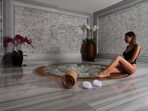 a woman in a black dress sitting in a room at Stella Di Mare Dubai Marina Hotel in Dubai