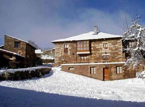 ein großes Backsteingebäude mit Schnee auf dem Boden in der Unterkunft Eido das Estrelas in Valdín