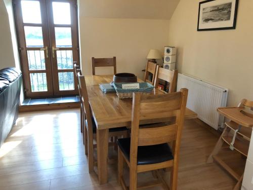 a dining room with a wooden table and chairs at Hael Farm Cottage in Swansea