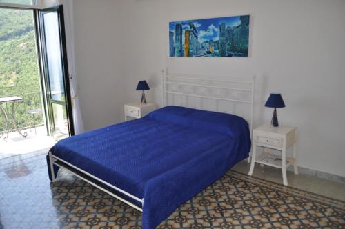 a bedroom with a blue bed and two night stands at villa verde sul mare in Vietri sul Mare