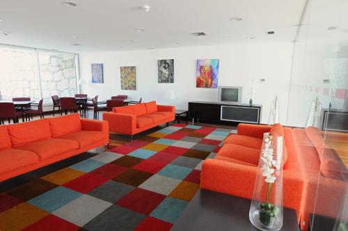 a living room with orange couches and a television at INATEL Vila Ruiva in Vila Ruiva