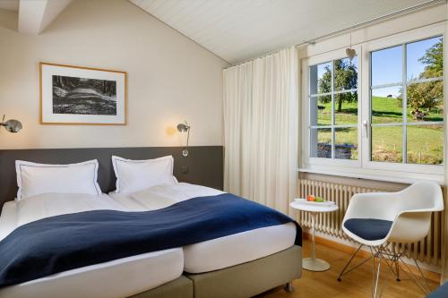 Un dormitorio con una cama grande y una ventana en Hotel Wassberg, en Forch