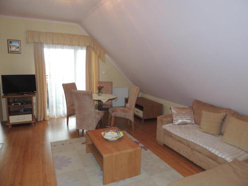 a living room with a couch and a table at Roselio Sky Residence in Hévíz