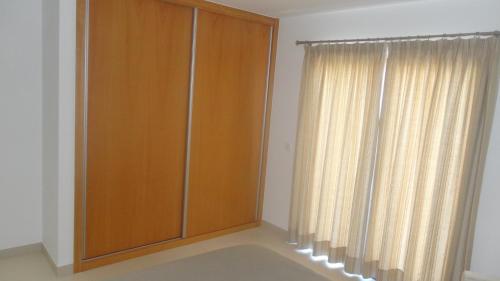 a wooden cabinet in a room with a window at Casa da Praia in Calheta