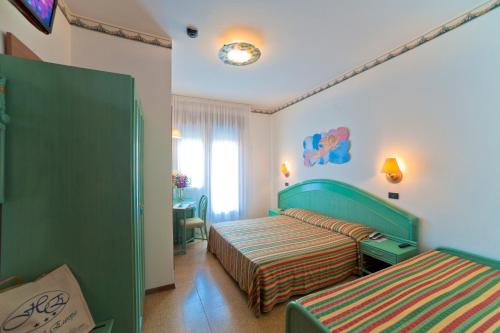 a hotel room with two beds and a window at Hotel Europa in Bibione