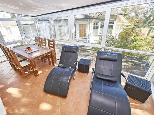 un porche cubierto con sillas y mesa en Villa Saxonia - WG 13 mit Wintergarten, strandnah en Binz