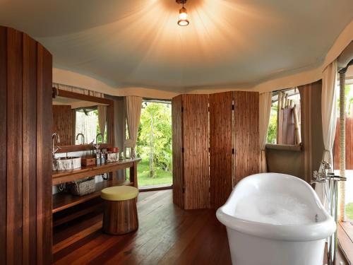 a bathroom with a white tub and a sink at 9 Hornbills Tented Camp in Ko Yao Noi