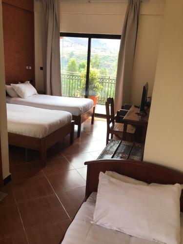 a hotel room with two beds and a balcony at Harbe Hotel in Lalībela