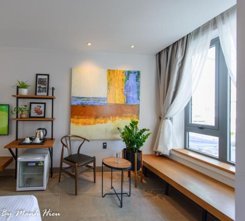 a living room with a desk and a window at Mojzo Inn Boutique Hotel in Nha Trang