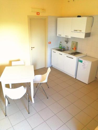a kitchen with a white table and chairs and a table and a counter at basilicata al volo in Brindisi di Montagna