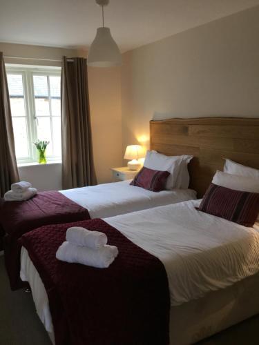two beds in a hotel room with towels on them at Upper Bray Cottage Badby, Daventry in Badby