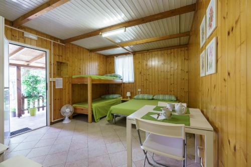多馬索的住宿－bungalow campeggio madonnina，客房配有双层床、桌子和书桌。