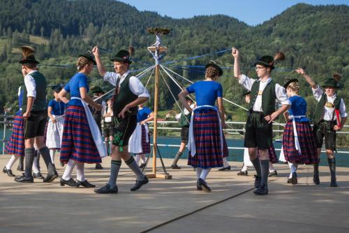 a group of people in kilts dancing on a bridge at Hotel Garni Gästehaus Brand in Bad Wiessee