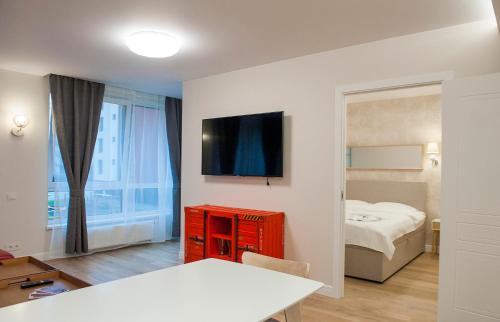 ヴィリニュスにあるNatalex Apartmentsの白い部屋(ベッド1台、赤いドレッサー付)