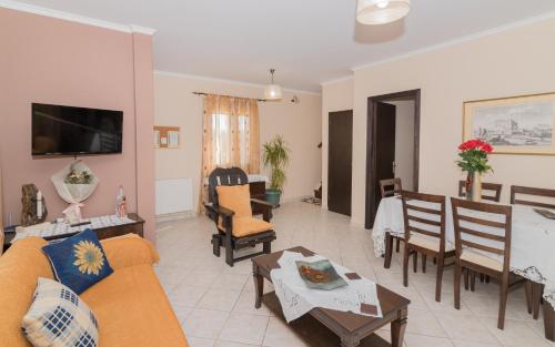 a living room with a couch and a dining room at Villa Lina in Pandokrátor