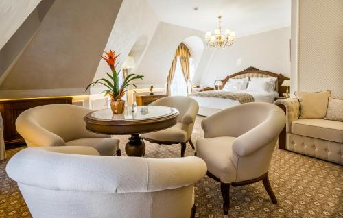 a hotel room with a bed and chairs and a table at Residence City Garden - Certificate of Excellence Top 10 BEST Five-Stars City Hotels for 2024 awarded by HTIF in Plovdiv