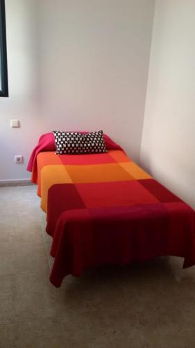 カレタ・デ・ファマラにあるCasa La Charca De Famaraのベッドルーム1室(カラフルな掛け布団付きのベッド2台付)