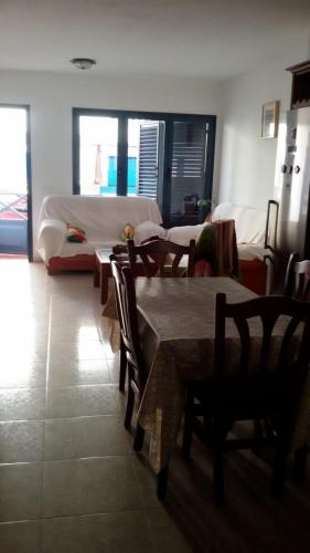 カレタ・デ・ファマラにあるCasa La Charca De Famaraのテーブル、椅子、ベッドが備わる客室です。