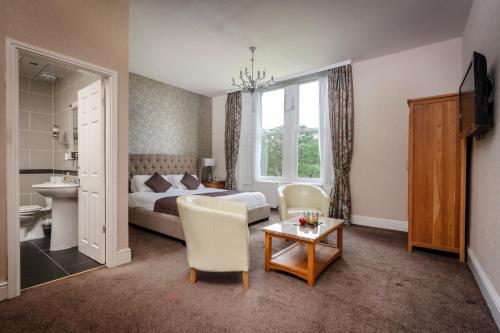 ein Hotelzimmer mit einem Bett, einem Tisch und Stühlen in der Unterkunft Burnley North Oaks Hotel and Leisure Club in Burnley