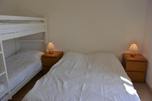 サリ・ソランザラにあるPALMERAIE 40のベッドルーム1室(二段ベッド2組、ランプ2つ付)