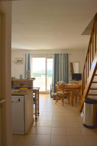 une cuisine et une salle à manger avec une table et une fenêtre dans l'établissement PALMERAIE 40, à Sari-Solenzara