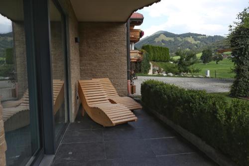 a wooden bench sitting on the side of a building at Pension Elisabeth in Sankt Jakob in Haus