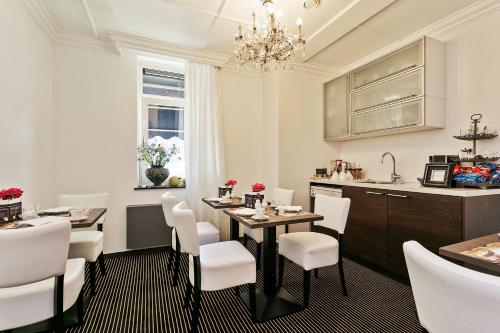 a dining room with a table and white chairs at Hotel Garni Villa Arrisja in Eefde