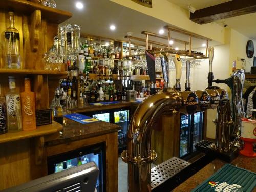 a bar with a bar counter with alcohol bottles at Ellesmere Hotel in Ellesmere