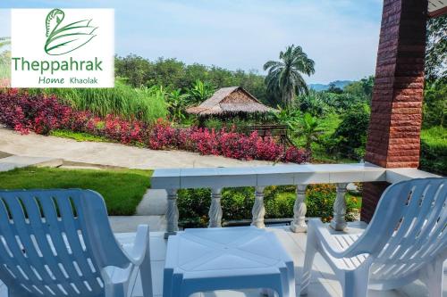 a patio with two chairs and a sign that reads theatemala house workshop at Theppahrak Home Khaolak in Khao Lak