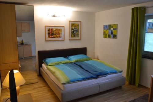 a bedroom with a bed with blue and yellow pillows at Apartment-Studio Kirisits in Mittersill