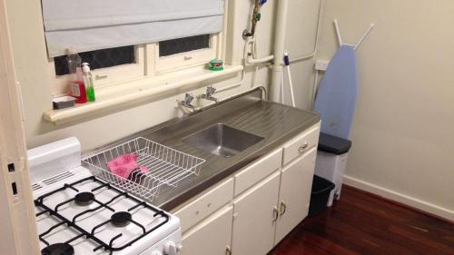 a small kitchen with a sink and a stove at Affordable & comfortable Apartment on Langley Park in Perth