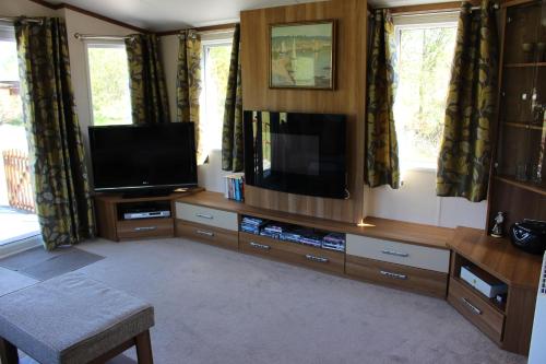 a living room with a flat screen tv and a entertainment center at Loch View in Taynuilt
