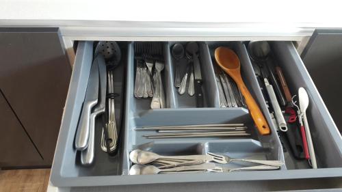 a drawer filled with utensils in a cabinet at Geoje Seaside Luxury Family Villa in Geoje 