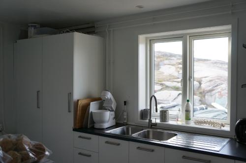 eine Küche mit einem Waschbecken und einem Fenster in der Unterkunft Hotel Nordlys in Oqaatsut